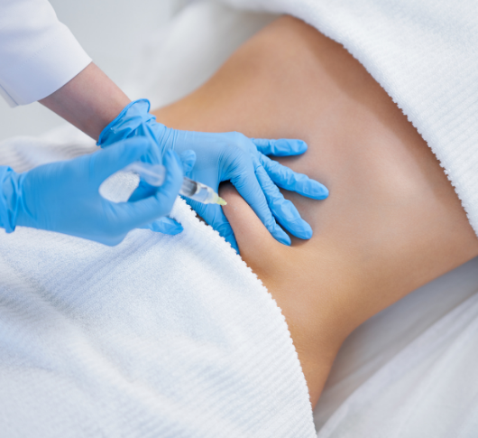 Blue-gloved hand performing fat dissolving injection on the side of the abdomen for localised fat reduction in non-invasive contouring