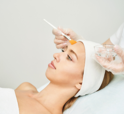 Aesthetician layers peel solution on relaxed face