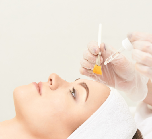 Chemical peel mask layered on face with brush
