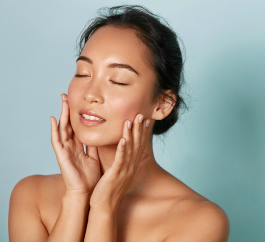 Young woman with eyes closed gently touching her face calmly