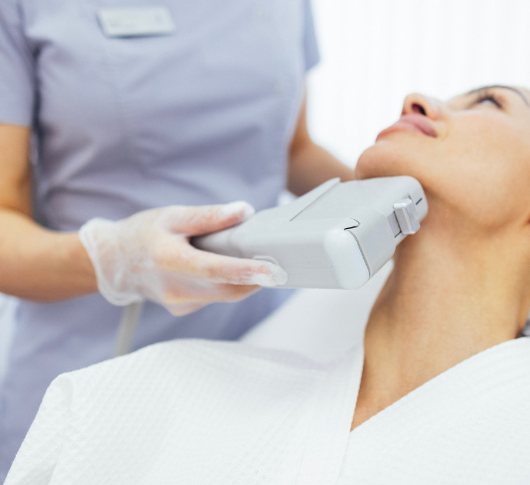 Close-up of a gloved aesthetician nurse during a non-invasive HIFU skin tightening treatment
