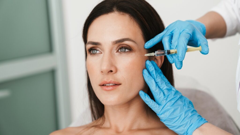 Patient receiving facial injection treatment near cheek area