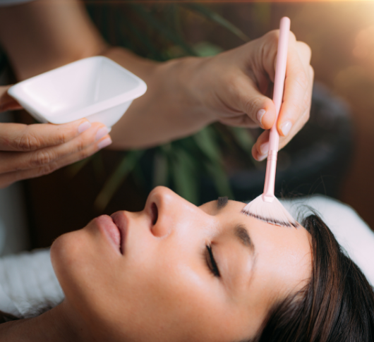 Aesthetician uses pink brush for chemical peel treatment