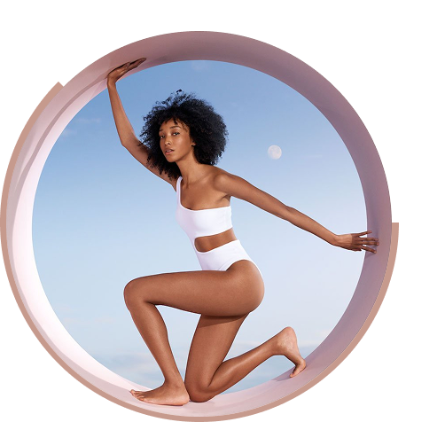 Model with afro hair posing in white swimsuit inside pink hoop