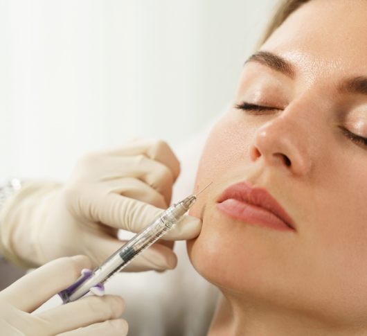 Gloved practitioner performing aesthetic treatment