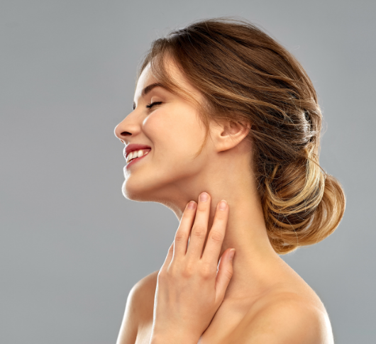 Woman smiling gently while touching her smooth neck